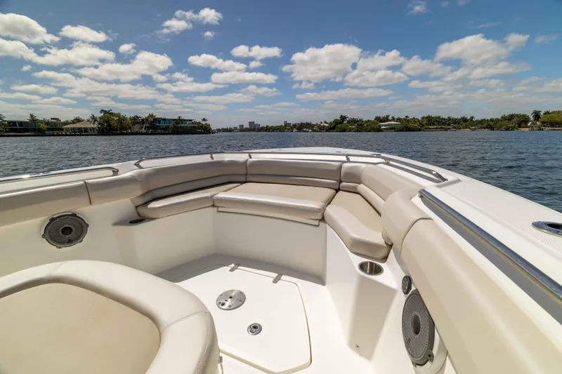 Slide: The Image of 2021 Boston Whaler 330 Outrage boat interior with cushioned seating on a sunny day. - 31