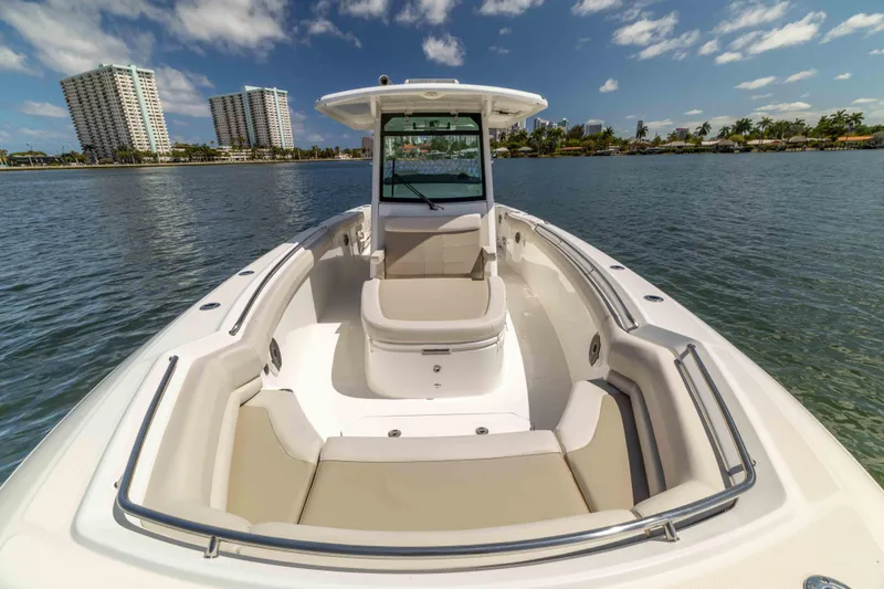 Slide: The Image of 2021 Boston Whaler 330 Outrage boat on calm water with city skyline background. - 33