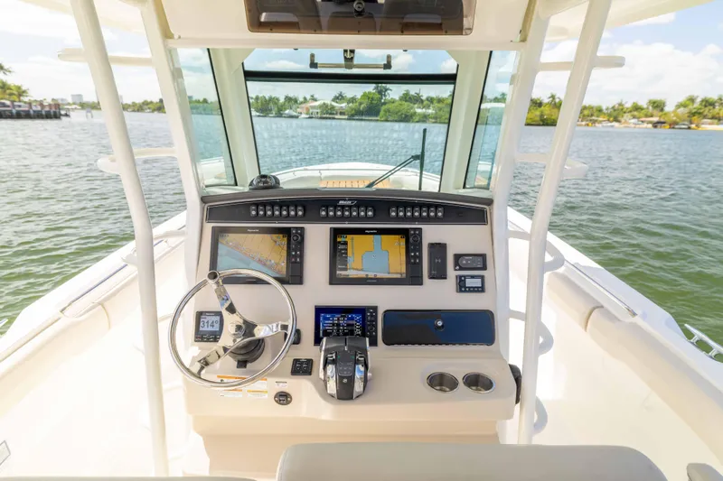 Slide: The Image of 2021 Boston Whaler 330 Outrage helm with advanced navigation systems and controls on open water. - 36