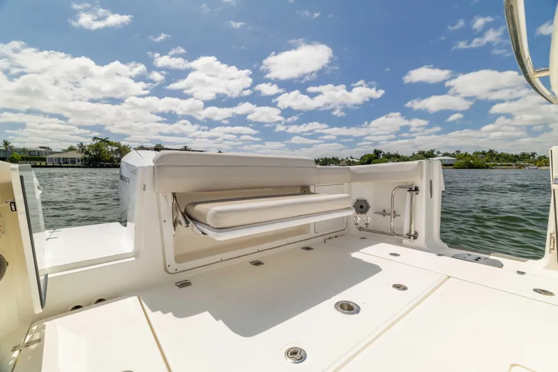 Slide: The Image of 2021 Boston Whaler 330 Outrage boat deck with seating, under a clear blue sky. - 41