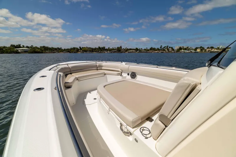 Slide: The Image of 2021 Boston Whaler 330 Outrage boat interior with seating, on calm water under blue sky. - 42