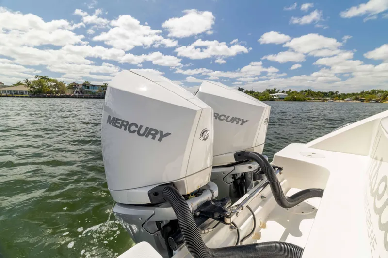 Slide: The Image of Twin Mercury outboard engines on a 2021 Boston Whaler 330 Outrage boat, on water. - 47