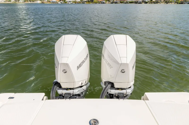 Slide: The Image of Twin Mercury outboard engines on a 2021 Boston Whaler 330 Outrage boat, on calm water. - 48