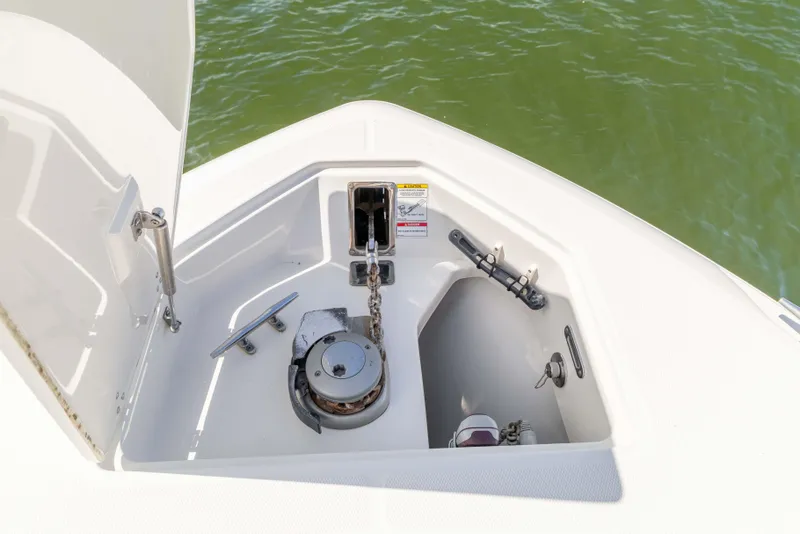 Slide: The Image of Anchor compartment of 2021 Boston Whaler 330 Outrage boat, featuring chain and cleat. - 49