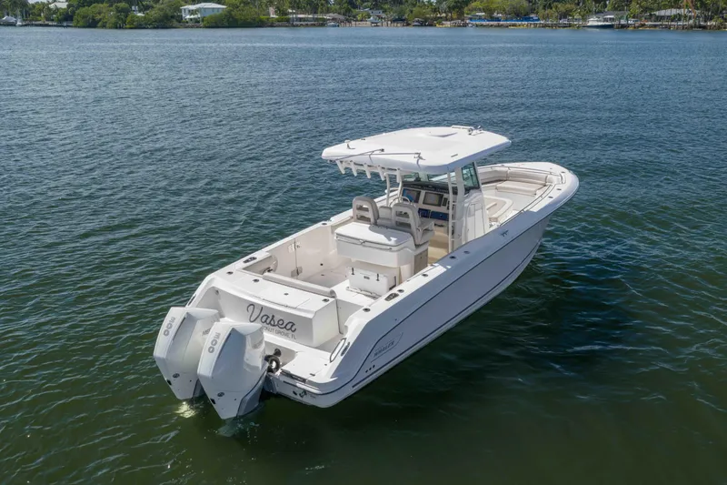 Slide: The Image of 2021 Boston Whaler 330 Outrage boat on calm water, featuring dual engines. - 6