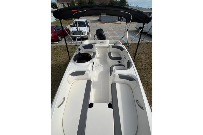 Slide: The Image of 2026 Bayliner Element E16 boat interior with seating and canopy, parked outdoors. - 16