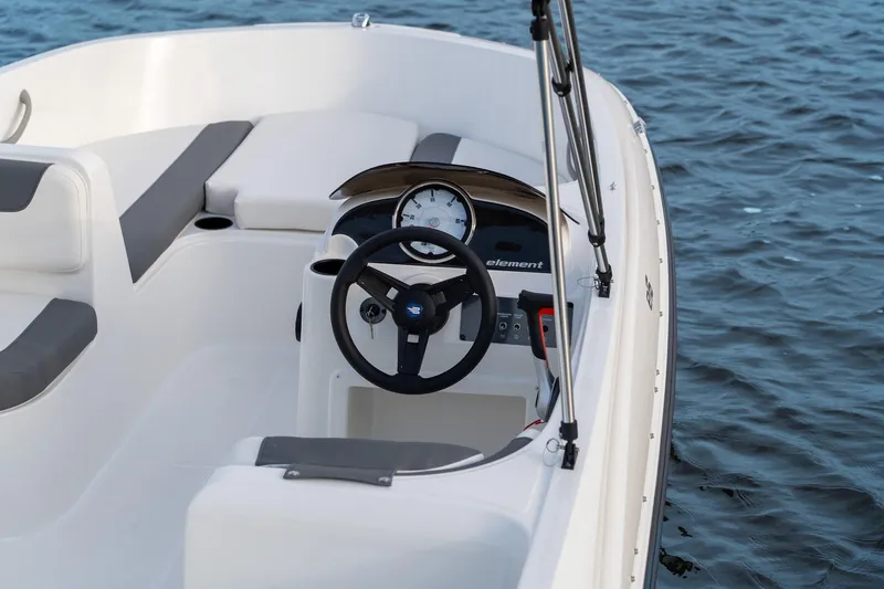 Slide: The Image of Manufacturer Provided Image: 2025 Bayliner Element E16 boat interior with steering wheel, dashboard, and seating on water. - 5