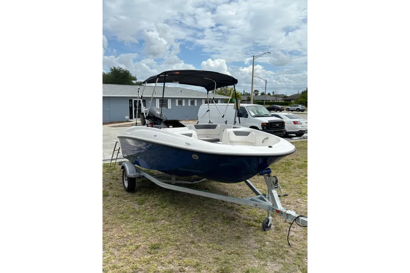Slide: The Image of 2026 Bayliner Element E16 boat on trailer, parked outdoors under cloudy sky. - 7