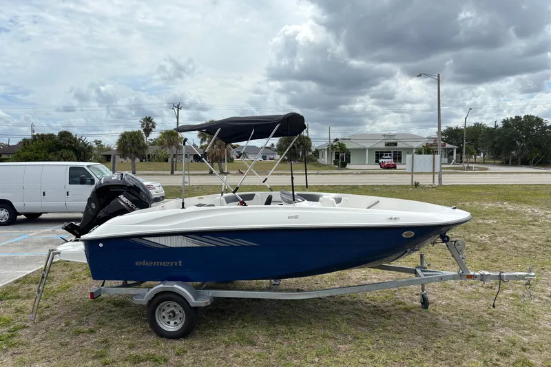 Slide: The Image of 2026 Bayliner Element E16 boat on trailer, parked outdoors under cloudy sky. - 8