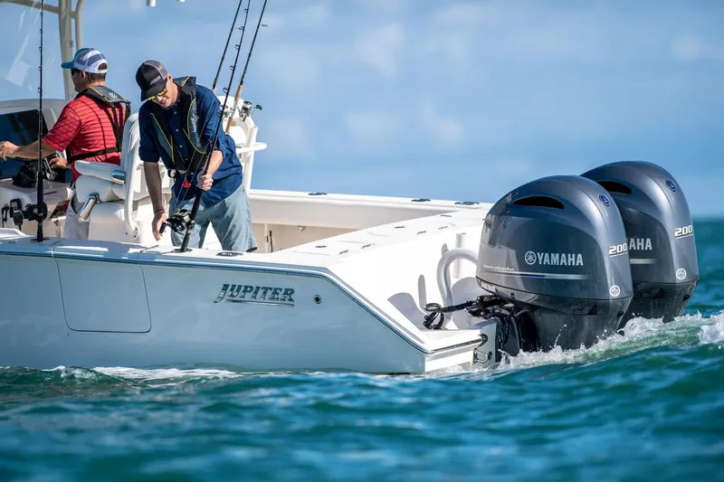 Slide: The Image of Two people fishing on a 2026 Jupiter 26 boat with Yamaha engines. - 2