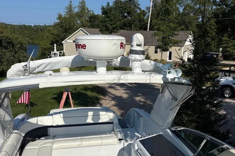 Slide: The Image of 2015 Formula 350 Crossover Bowrider with radar equipment, docked near a lakeside house. - 16