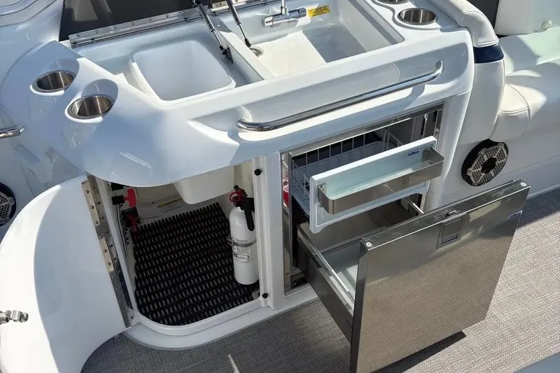 Slide: The Image of 2015 Formula 350 Crossover Bowrider boat kitchen with sink, fridge, and storage. - 18