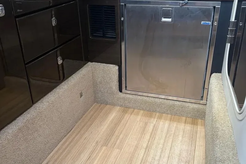 Slide: The Image of Interior of 2015 Formula 350 Crossover Bowrider with wood flooring and stainless steel fridge. - 32