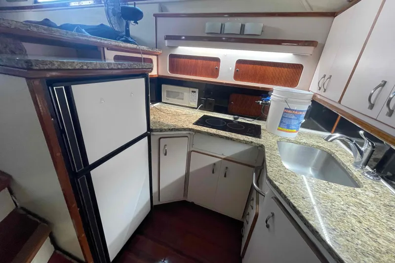 Slide: The Image of 1989 Sea Ray 380 Aft Cabin kitchen with granite countertops, stove, and sink. - 13