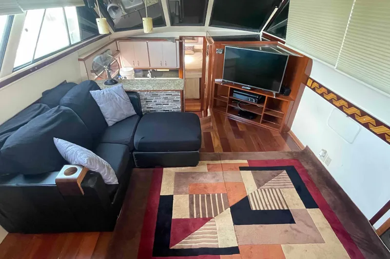 Slide: The Image of Interior of 1989 Sea Ray 380 Aft Cabin with sofa, TV, and modern decor. - 2