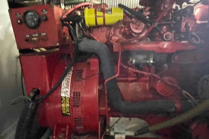 Slide: The Image of Engine compartment of a 1989 Sea Ray 380 Aft Cabin boat, featuring a red Westerbeke generator. - 25