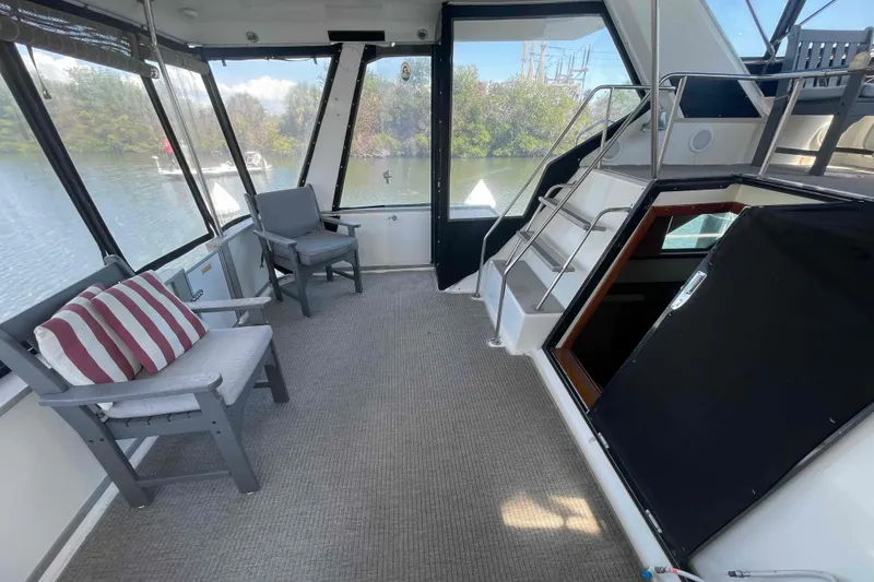 Slide: The Image of 1989 Sea Ray 380 Aft Cabin interior with seating, carpet, and scenic water view. - 45