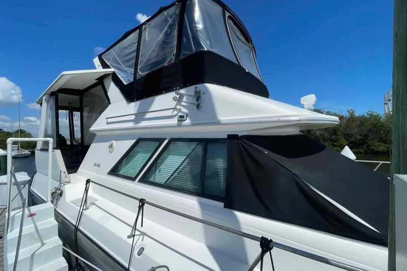 Slide: The Image of 1989 Sea Ray 380 Aft Cabin yacht docked under clear blue sky. - 48
