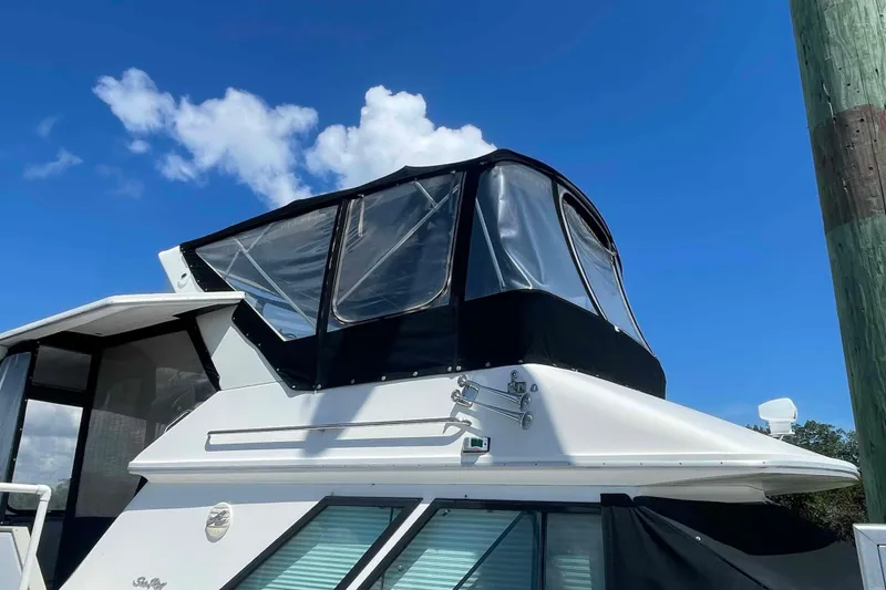 Slide: The Image of 1989 Sea Ray 380 Aft Cabin yacht with black canopy under clear blue sky. - 49