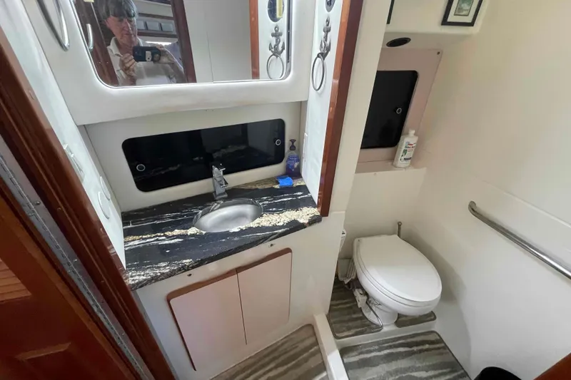 Slide: The Image of 1989 Sea Ray 380 Aft Cabin bathroom with sink, mirror, and toilet. - 5