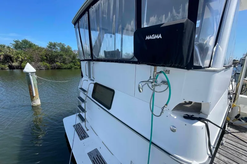 Slide: The Image of 1989 Sea Ray 380 Aft Cabin yacht docked by a serene waterway. - 50