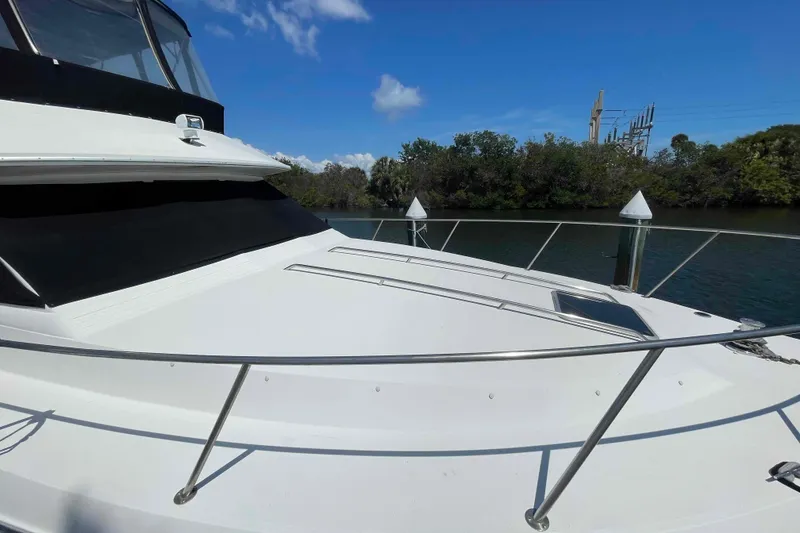 Slide: The Image of 1989 Sea Ray 380 Aft Cabin yacht docked by a serene waterway. - 52