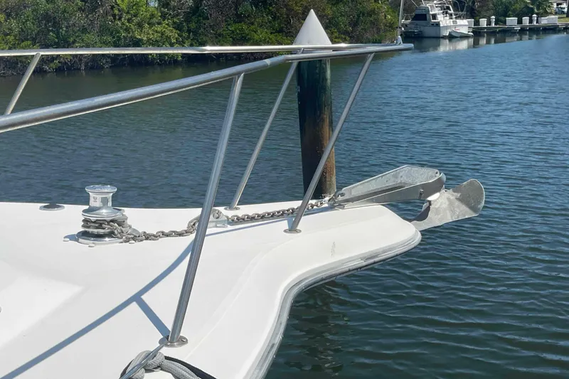 Slide: The Image of Bow of 1989 Sea Ray 380 Aft Cabin with anchor and railing on calm water. - 53