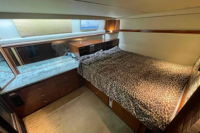 Slide: The Image of 1989 Sea Ray 380 Aft Cabin bedroom with leopard print bedding and wooden cabinetry. - 7