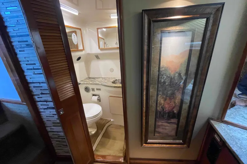Slide: The Image of 1989 Sea Ray 380 Aft Cabin bathroom with framed artwork and granite countertop. - 8