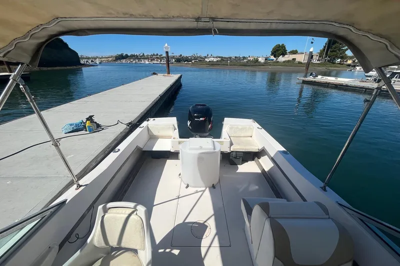 Slide: The Image of 1986 Grady-White Tournament 190 boat docked, featuring spacious seating and canopy. - 11