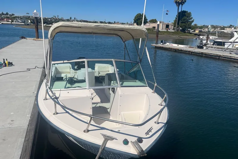 Slide: The Image of 1986 Grady-White Tournament 190 boat docked on calm water. - 2