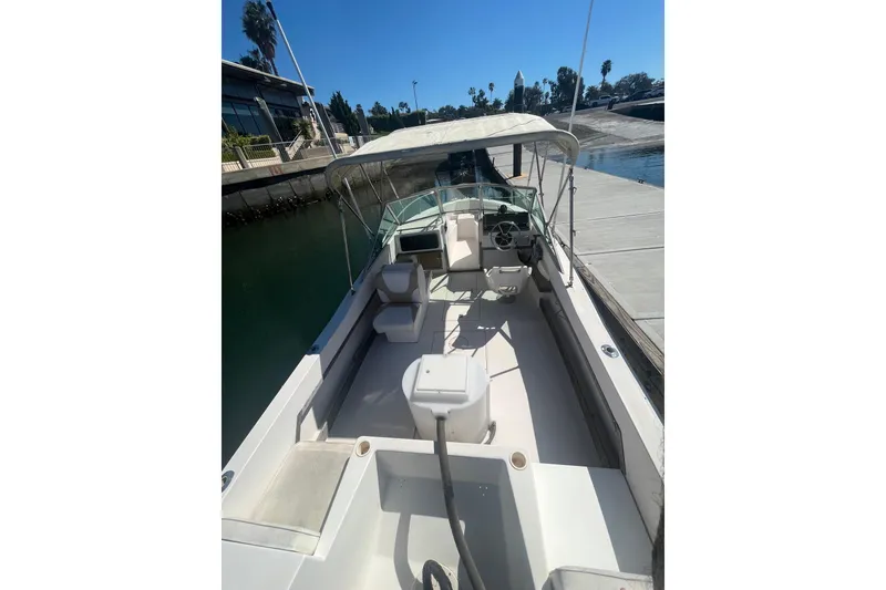 Slide: The Image of 1986 Grady-White Tournament 190 boat docked, featuring spacious seating and canopy. - 5