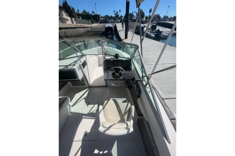 Slide: The Image of 1986 Grady-White Tournament 190 boat interior at dock, featuring steering wheel and seating. - 7