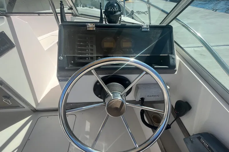Slide: The Image of 1986 Grady-White Tournament 190 boat helm with steering wheel and Garmin navigation system. - 8