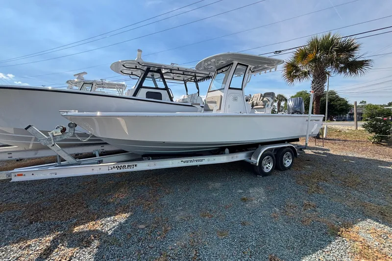 The Image of 2027 Sportsman Masters 247OE Bay Boat on trailer, parked outdoors under clear sky. - 14