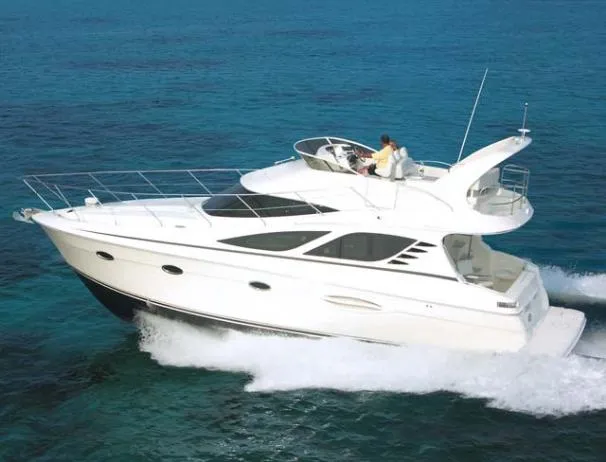 The Image of 2006 Silverton 38 Sport Bridge yacht docked in a marina, featuring sleek design and spacious upper deck. - 0