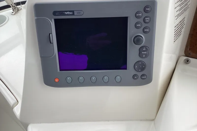 Slide: The Image of 2006 Silverton 38 Sport Bridge helm with compass and control panel. - 11