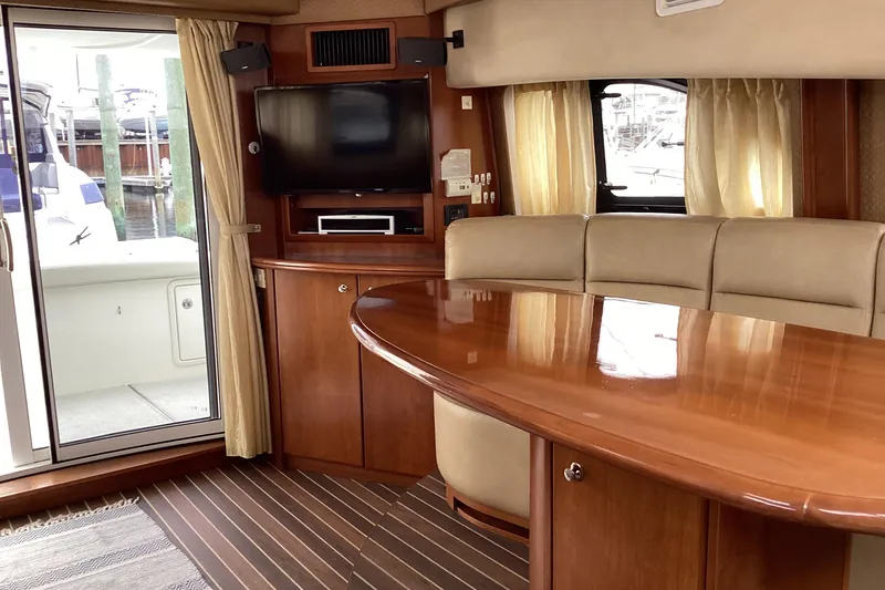 Slide: The Image of Luxurious interior of 2006 Silverton 38 Sport Bridge with plush seating and wooden table. - 16