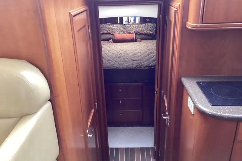 Slide: The Image of 2006 Silverton 38 Sport Bridge cabin with wooden drawers and cushioned bed. - 25