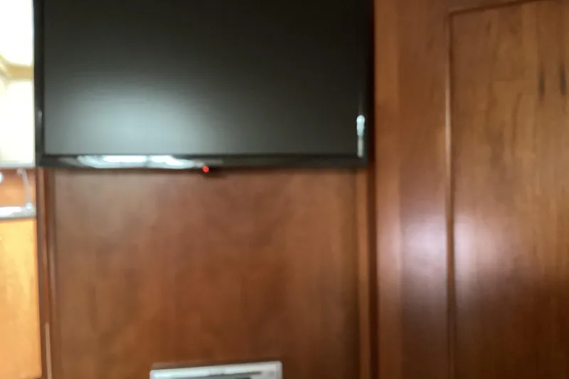 Slide: The Image of Flat-screen TV mounted on wooden wall inside 2006 Silverton 38 Sport Bridge yacht. - 30