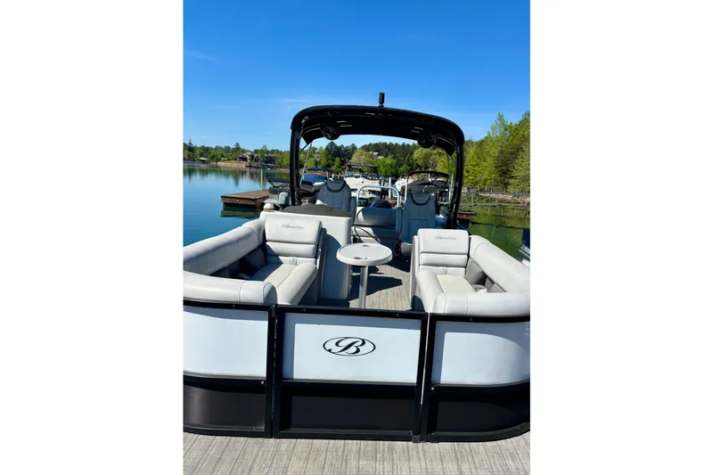 Slide: The Image of 2022 Bentley Pontoons Elite 253 Swingback on a serene lake with lush greenery. - 6