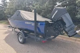 The Image of 2019 Crestliner 1850 Fish Hawk WT boat with Mercury outboard motor, parked on a trailer. - 1
