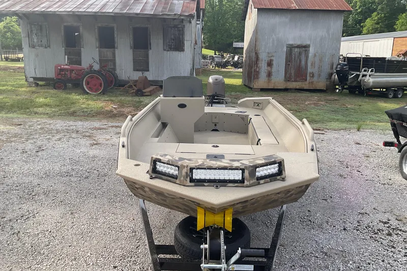 Slide: The Image of 2026 Excel 1751 River Warrior SC boat on trailer, rustic background. - 2