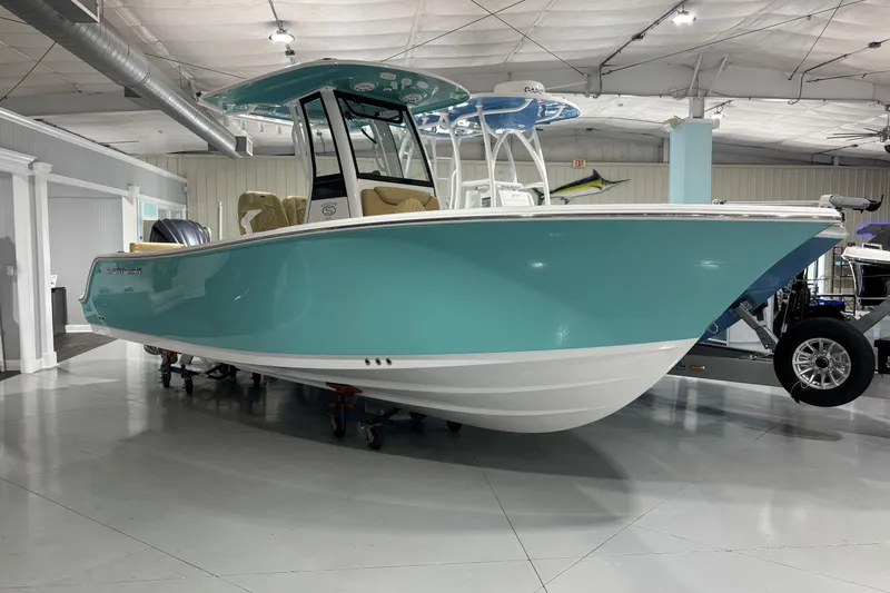 The Image of 2027 Sportsman Heritage 231 Center Console boat in showroom, turquoise hull, modern design. - 10