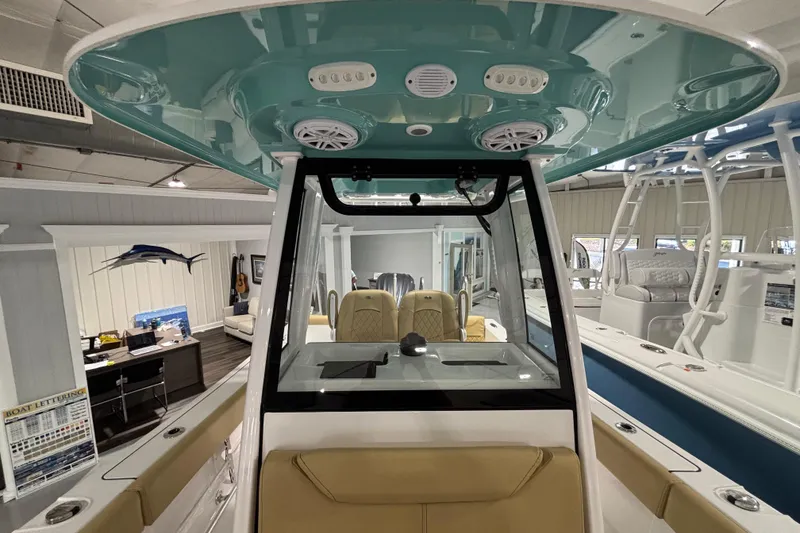 Slide: The Image of 2027 Sportsman Heritage 231 Center Console boat interior with teal ceiling and beige seating. - 16