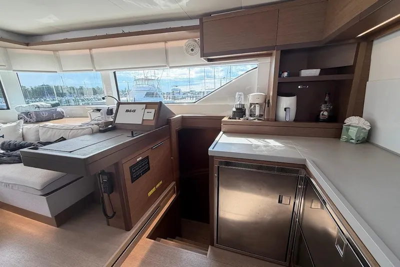 Slide: The Image of Interior of a 2021 Lagoon 50 yacht featuring a modern kitchen and navigation area. - 11