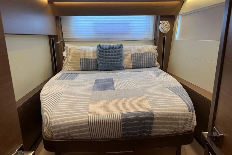 Slide: The Image of Cozy bedroom interior of 2021 Lagoon 50 yacht with striped bedding and soft lighting. - 18