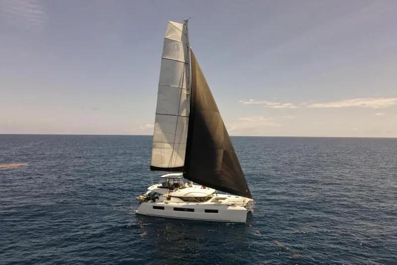 Slide: The Image of 2021 Lagoon 50 catamaran sailing on open sea under clear skies. - 2