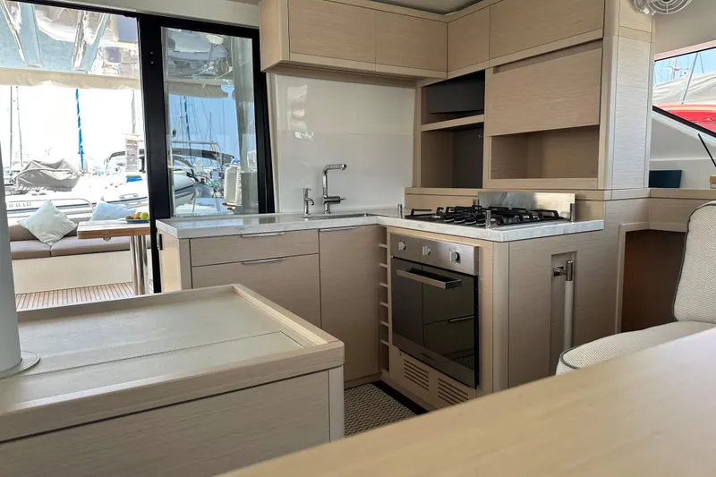Slide: The Image of Modern kitchen interior on a 2021 Lagoon 50 yacht, featuring sleek cabinetry and appliances. - 5