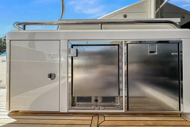 Slide: The Image of Riviera 4800 Sport Yacht 2020 outdoor kitchen with stainless steel appliances on deck. - 25